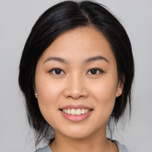 Joyful asian young-adult female with medium  black hair and brown eyes