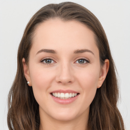 Joyful white young-adult female with long  brown hair and grey eyes