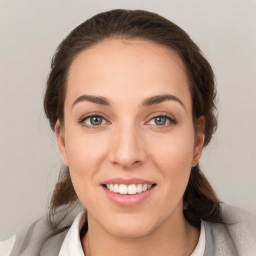 Joyful white young-adult female with medium  brown hair and grey eyes