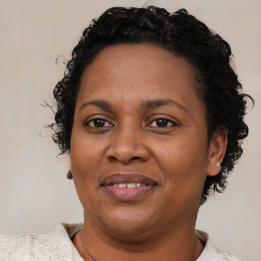 Joyful black adult female with short  brown hair and brown eyes