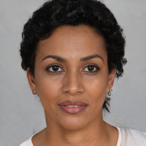 Joyful black young-adult female with short  black hair and brown eyes