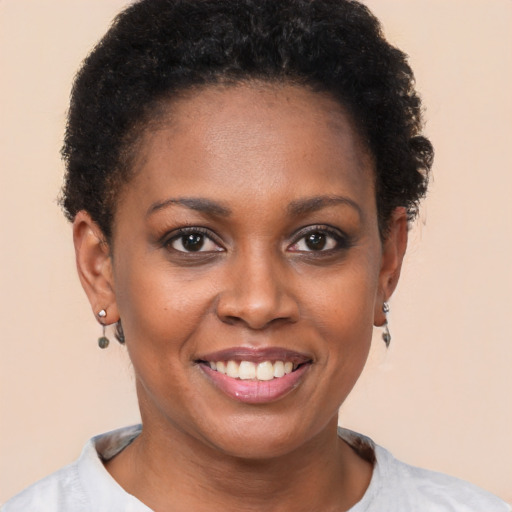 Joyful black young-adult female with short  brown hair and brown eyes