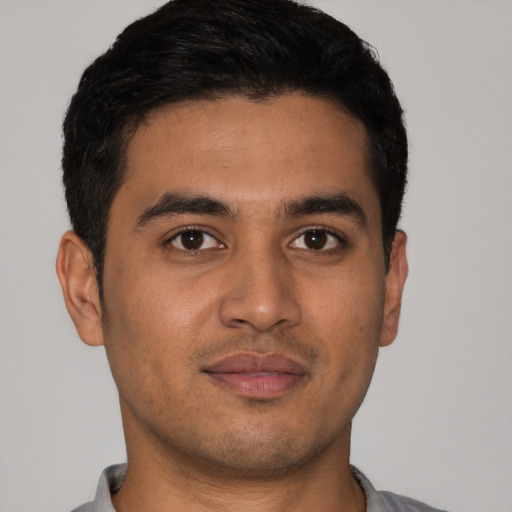 Joyful latino young-adult male with short  black hair and brown eyes