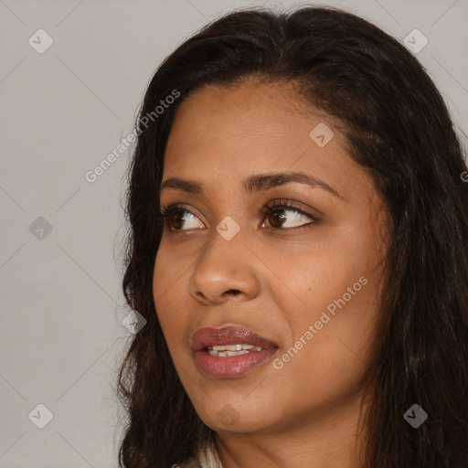 Joyful black young-adult female with long  brown hair and brown eyes