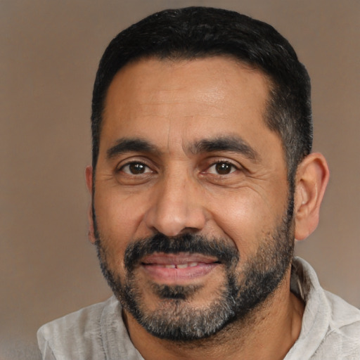 Joyful latino adult male with short  black hair and brown eyes