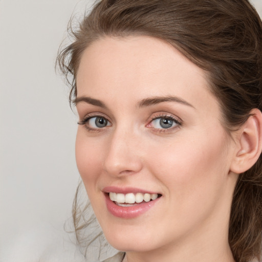 Joyful white young-adult female with medium  brown hair and blue eyes