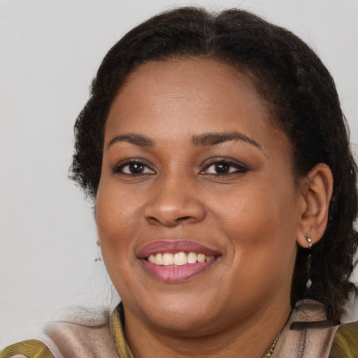 Joyful black young-adult female with long  brown hair and brown eyes