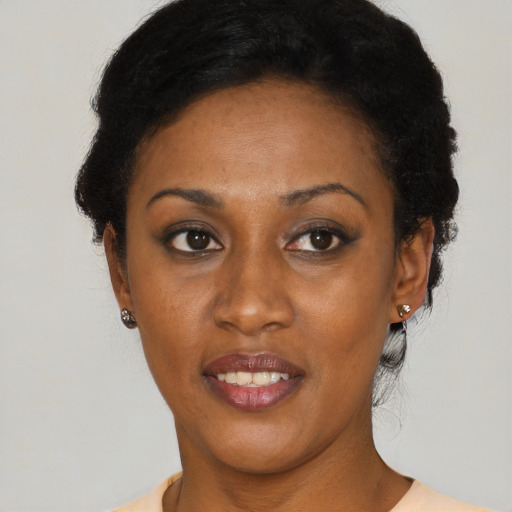 Joyful black young-adult female with short  black hair and brown eyes