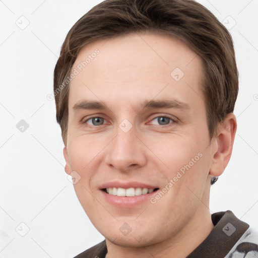 Joyful white young-adult male with short  brown hair and grey eyes