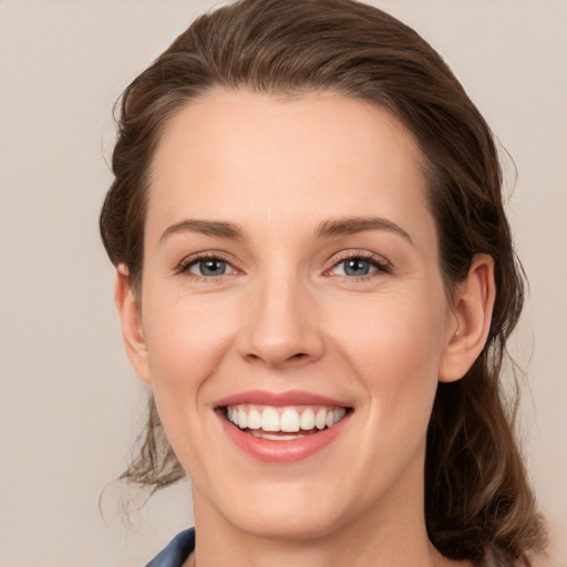 Joyful white young-adult female with medium  brown hair and grey eyes