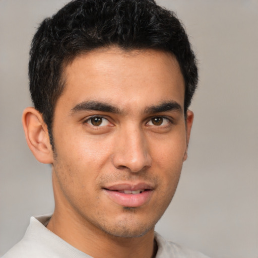 Joyful latino young-adult male with short  brown hair and brown eyes