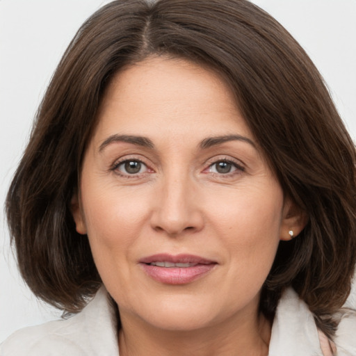 Joyful white adult female with medium  brown hair and brown eyes