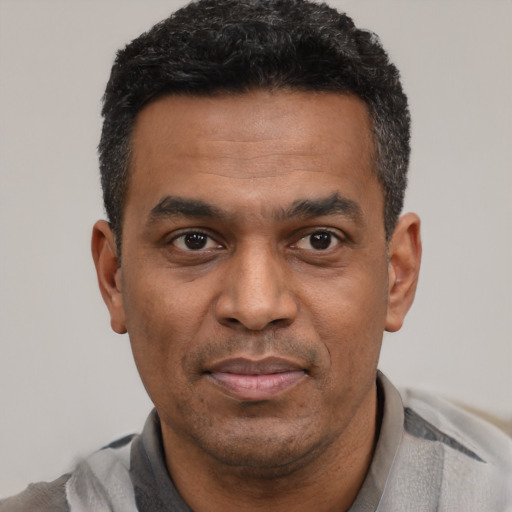 Joyful latino adult male with short  black hair and brown eyes