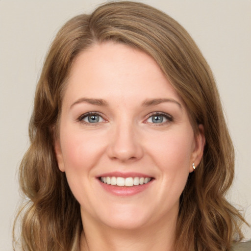 Joyful white young-adult female with long  brown hair and green eyes