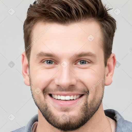 Joyful white young-adult male with short  brown hair and grey eyes