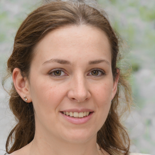 Joyful white young-adult female with medium  brown hair and green eyes