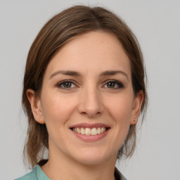 Joyful white young-adult female with medium  brown hair and grey eyes