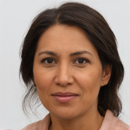 Joyful latino adult female with medium  brown hair and brown eyes