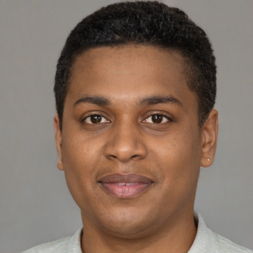 Joyful black young-adult male with short  brown hair and brown eyes