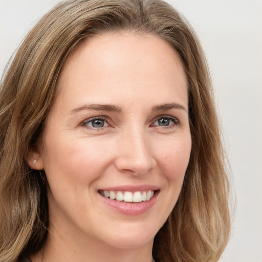 Joyful white young-adult female with long  brown hair and blue eyes