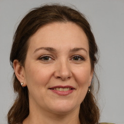 Joyful white adult female with medium  brown hair and grey eyes