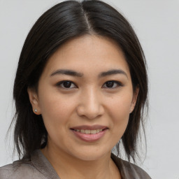 Joyful asian young-adult female with medium  brown hair and brown eyes