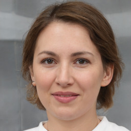 Joyful white adult female with medium  brown hair and brown eyes