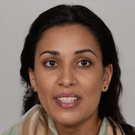 Joyful latino adult female with medium  brown hair and brown eyes