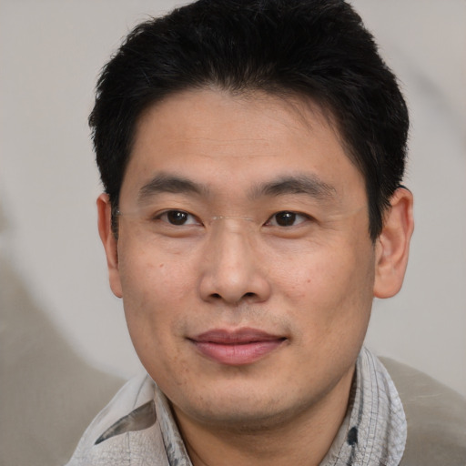 Joyful asian young-adult male with short  black hair and brown eyes