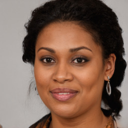 Joyful black adult female with long  brown hair and brown eyes