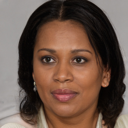 Joyful black adult female with medium  brown hair and brown eyes