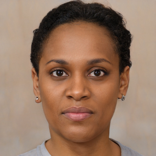 Joyful black young-adult female with short  brown hair and brown eyes