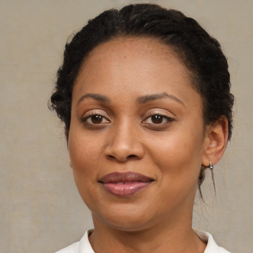 Joyful black adult female with medium  brown hair and brown eyes
