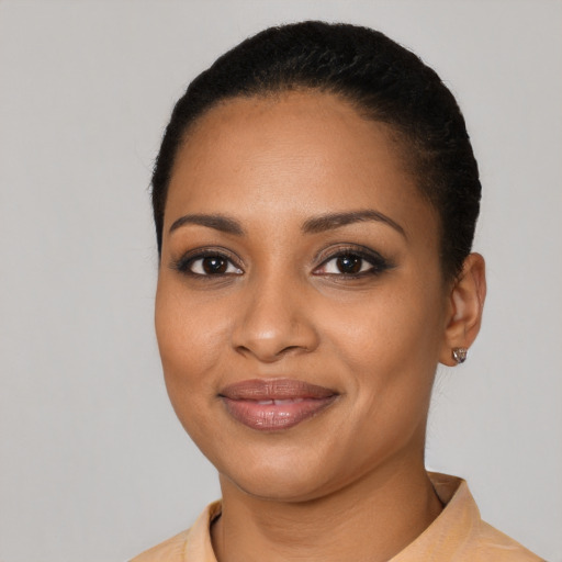 Joyful black young-adult female with short  black hair and brown eyes