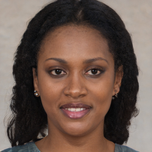 Joyful black young-adult female with long  black hair and brown eyes