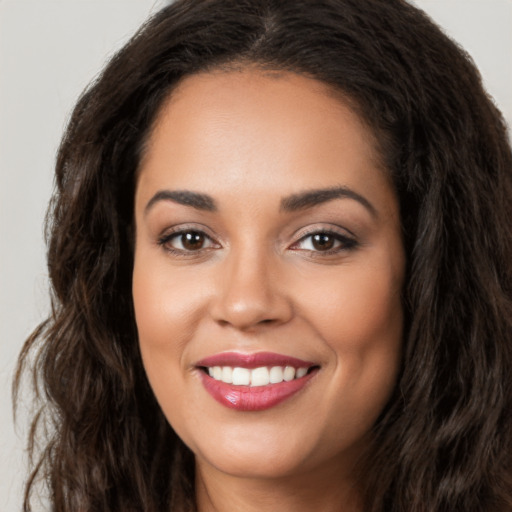 Joyful latino young-adult female with long  brown hair and brown eyes