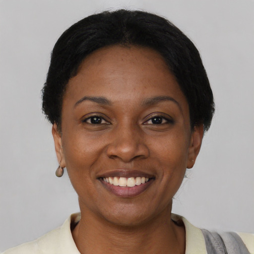 Joyful black young-adult female with short  black hair and brown eyes