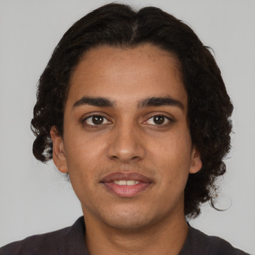Joyful black young-adult male with short  brown hair and brown eyes