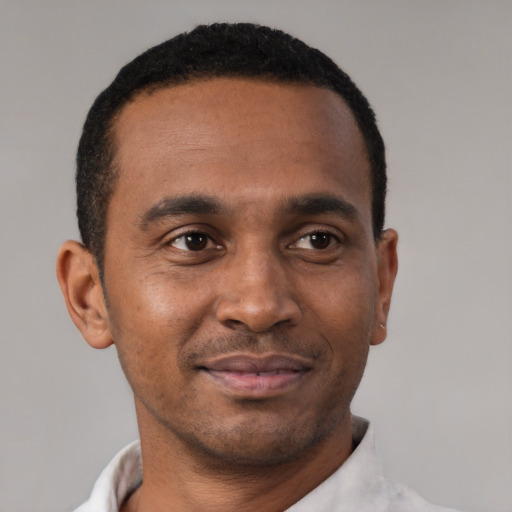 Joyful black young-adult male with short  brown hair and brown eyes
