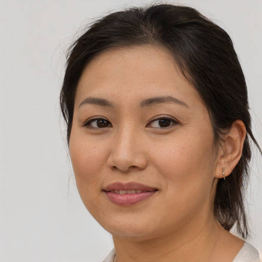 Joyful asian adult female with medium  brown hair and brown eyes