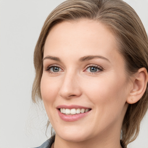 Joyful white young-adult female with medium  brown hair and grey eyes