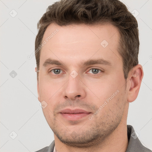 Joyful white young-adult male with short  brown hair and grey eyes