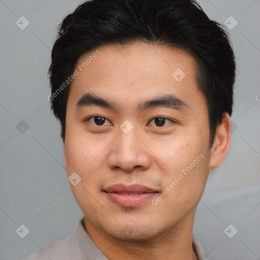 Joyful asian young-adult male with short  brown hair and brown eyes