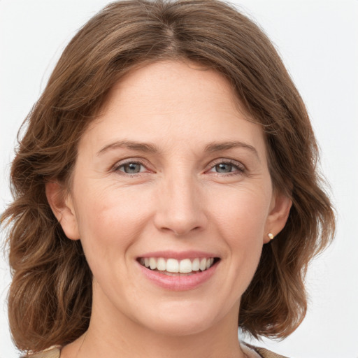 Joyful white young-adult female with medium  brown hair and green eyes