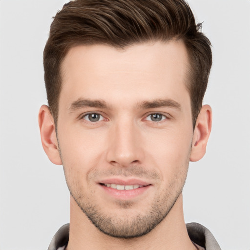 Joyful white young-adult male with short  brown hair and grey eyes