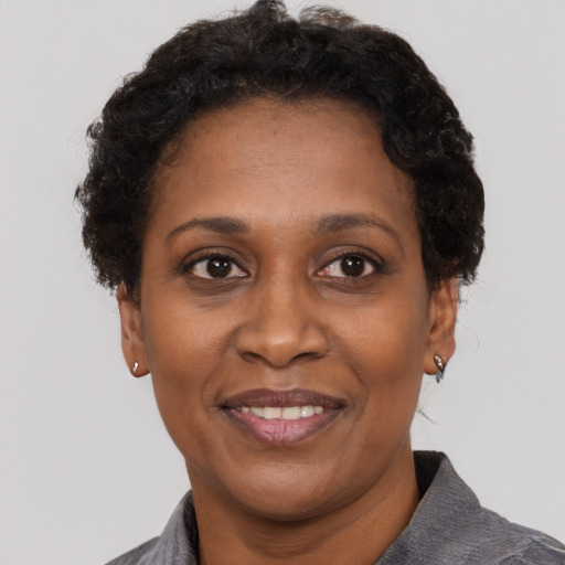 Joyful black adult female with short  black hair and brown eyes