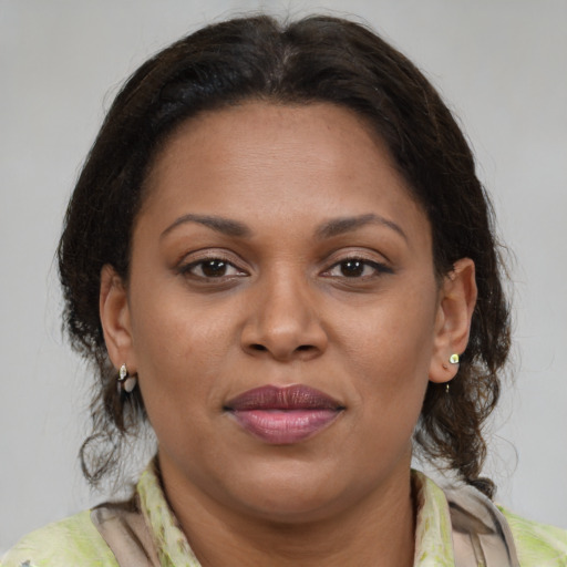 Joyful latino adult female with medium  brown hair and brown eyes