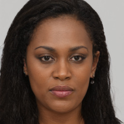 Joyful black young-adult female with long  brown hair and brown eyes