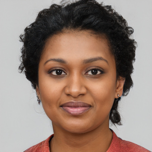 Joyful black young-adult female with long  black hair and brown eyes