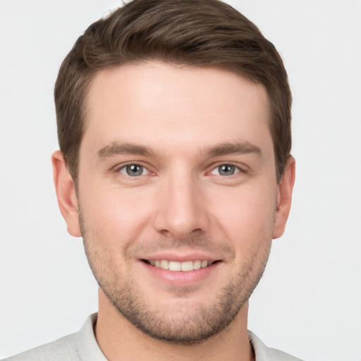 Joyful white young-adult male with short  brown hair and grey eyes